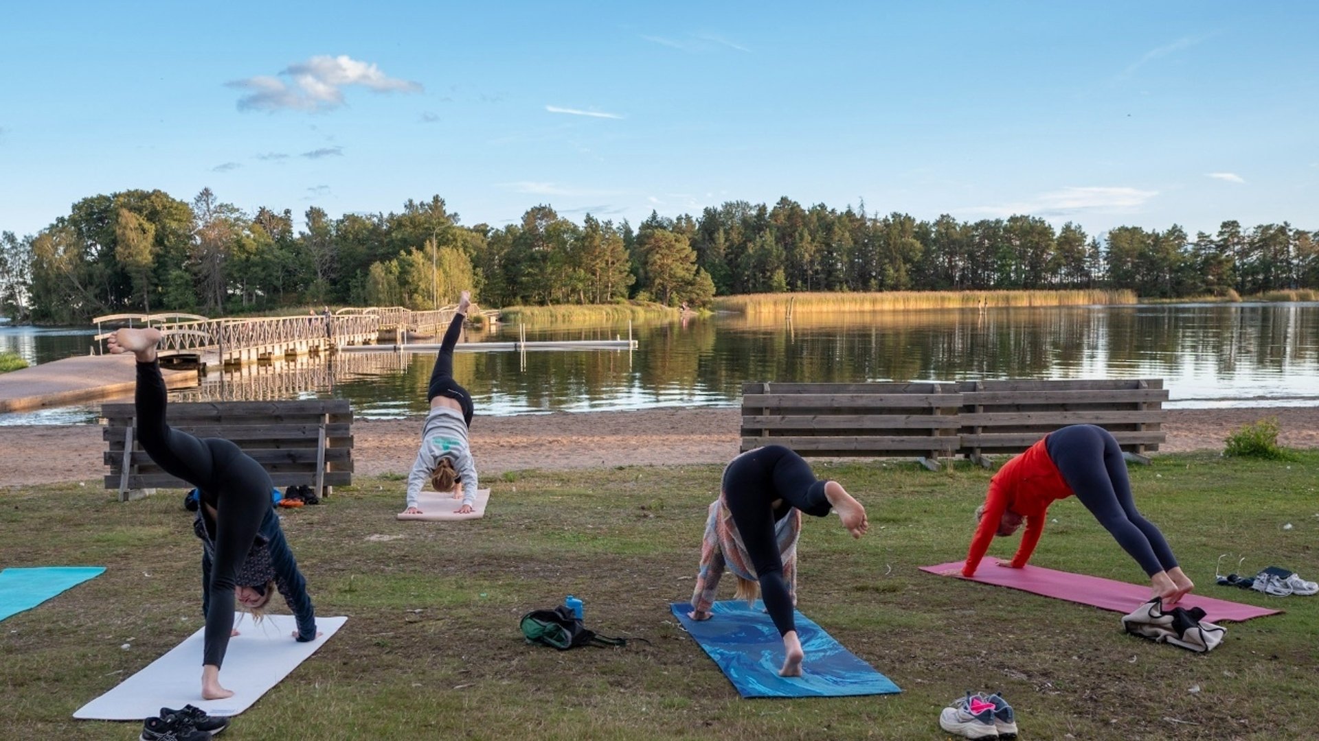 Bild på en grupp människor som yogar på en vacker strand.