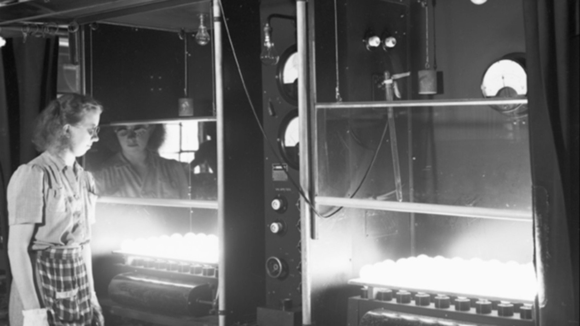 Kvinna kontrollerar glödlampor vid Glödlampsfabriken.