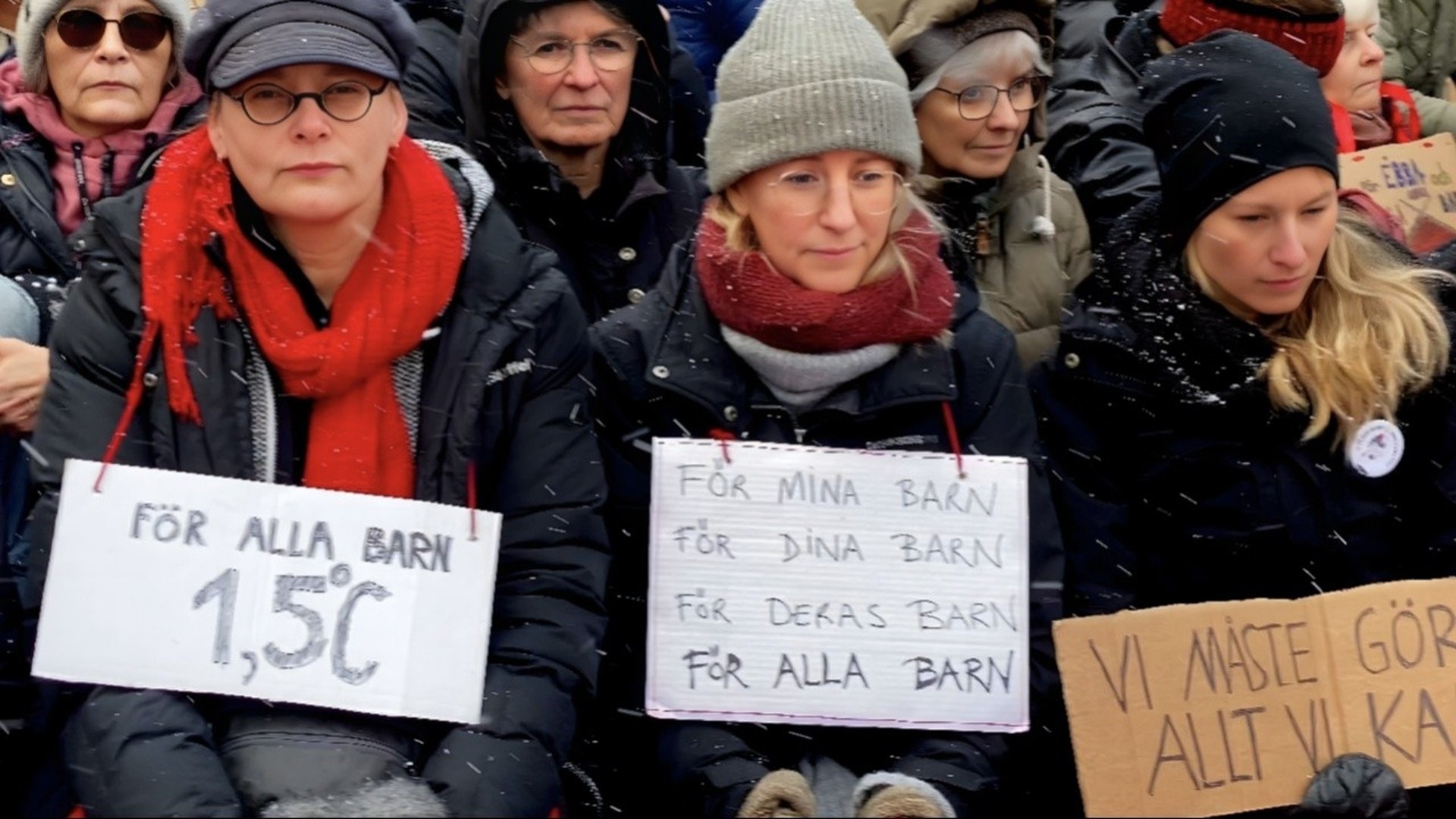 Bilden visar tre kvinnor som håller i plakat med texter om att hindra den globala uppvärmningen.