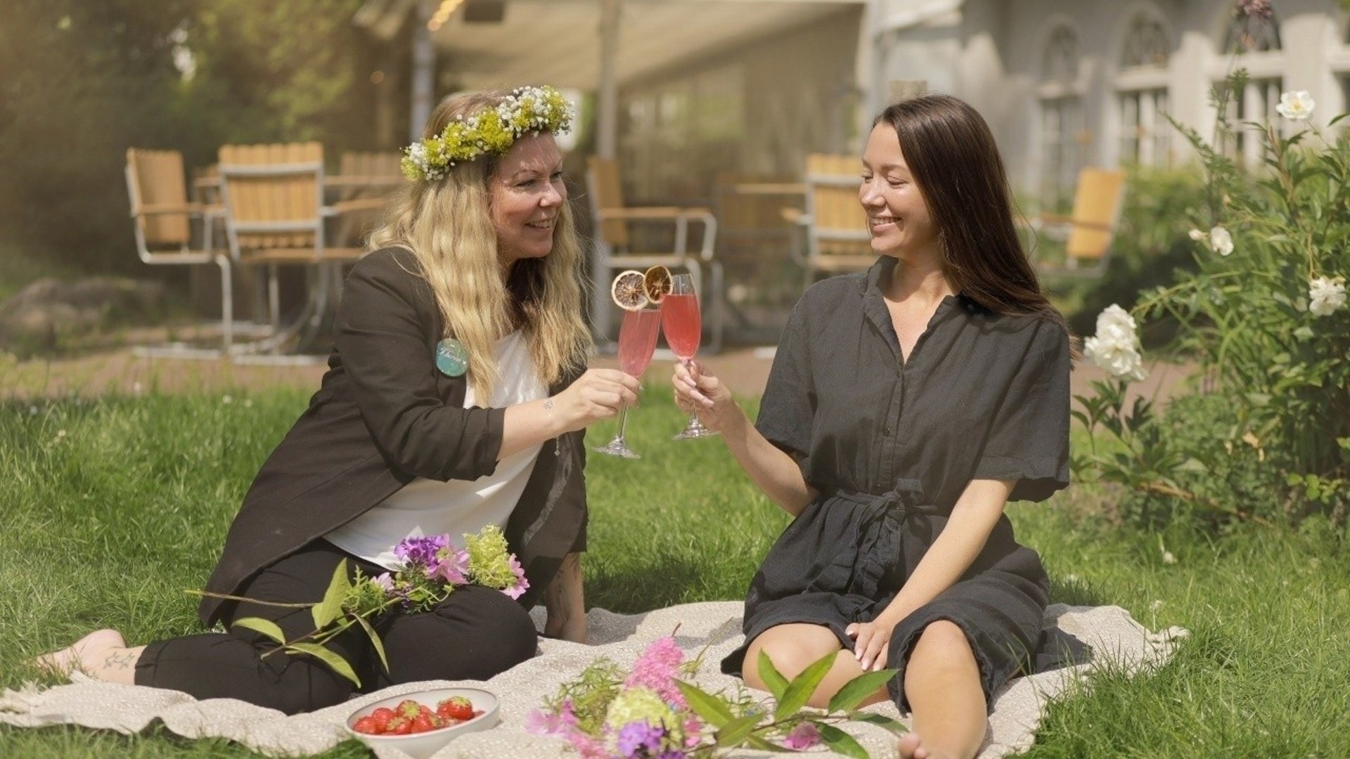 Två kvinnor som har picknick i det gröna