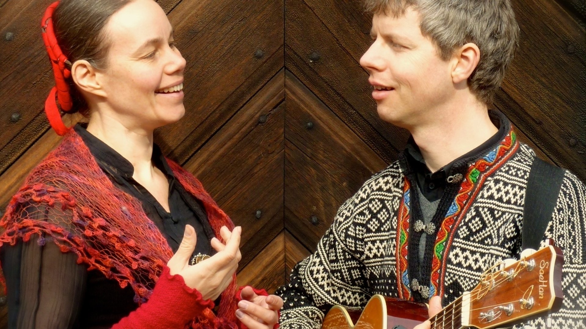 En kvinnlig och en manlig musiker i folkdräktsliknande kläder