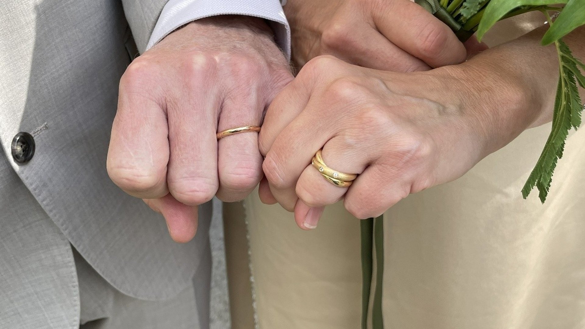 Händer med vigselringar.