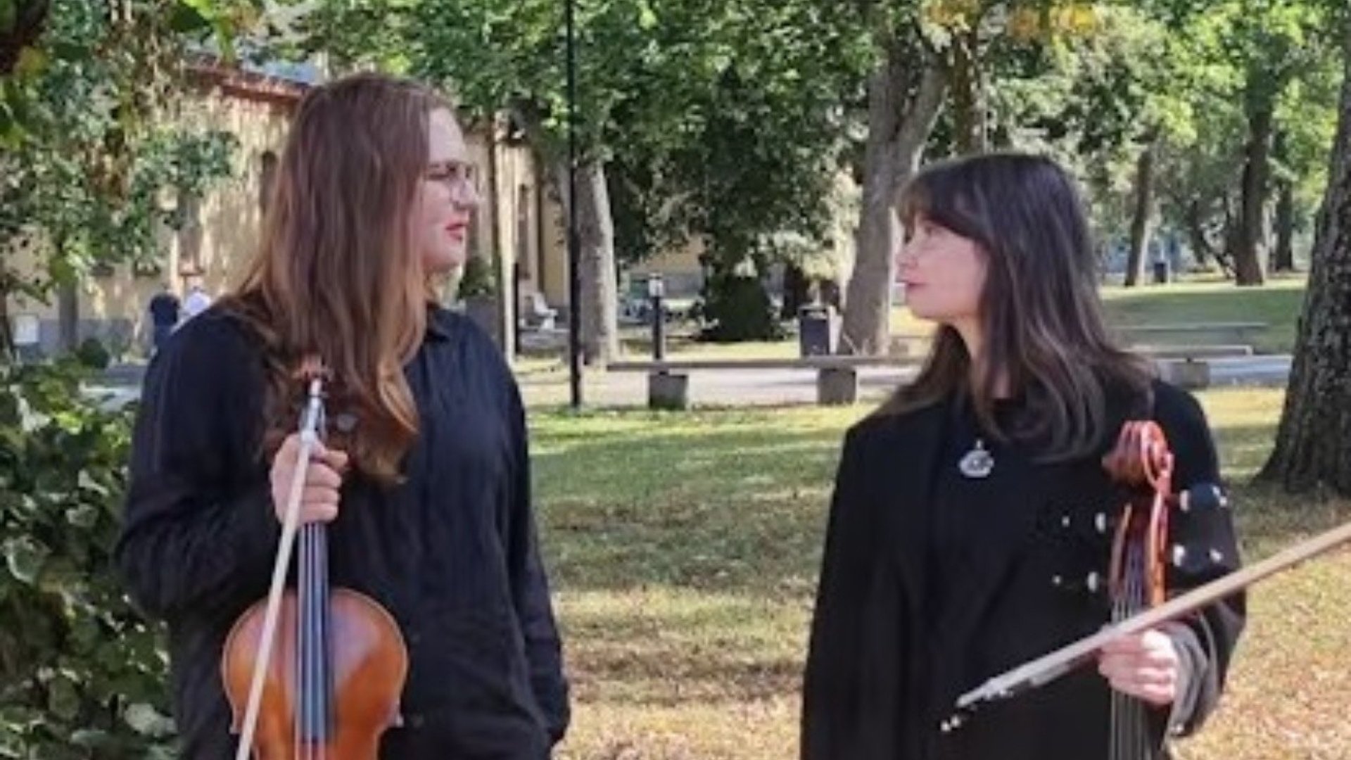 Filippa och Stina i en park med sina instrument, altfiolen och cellon.