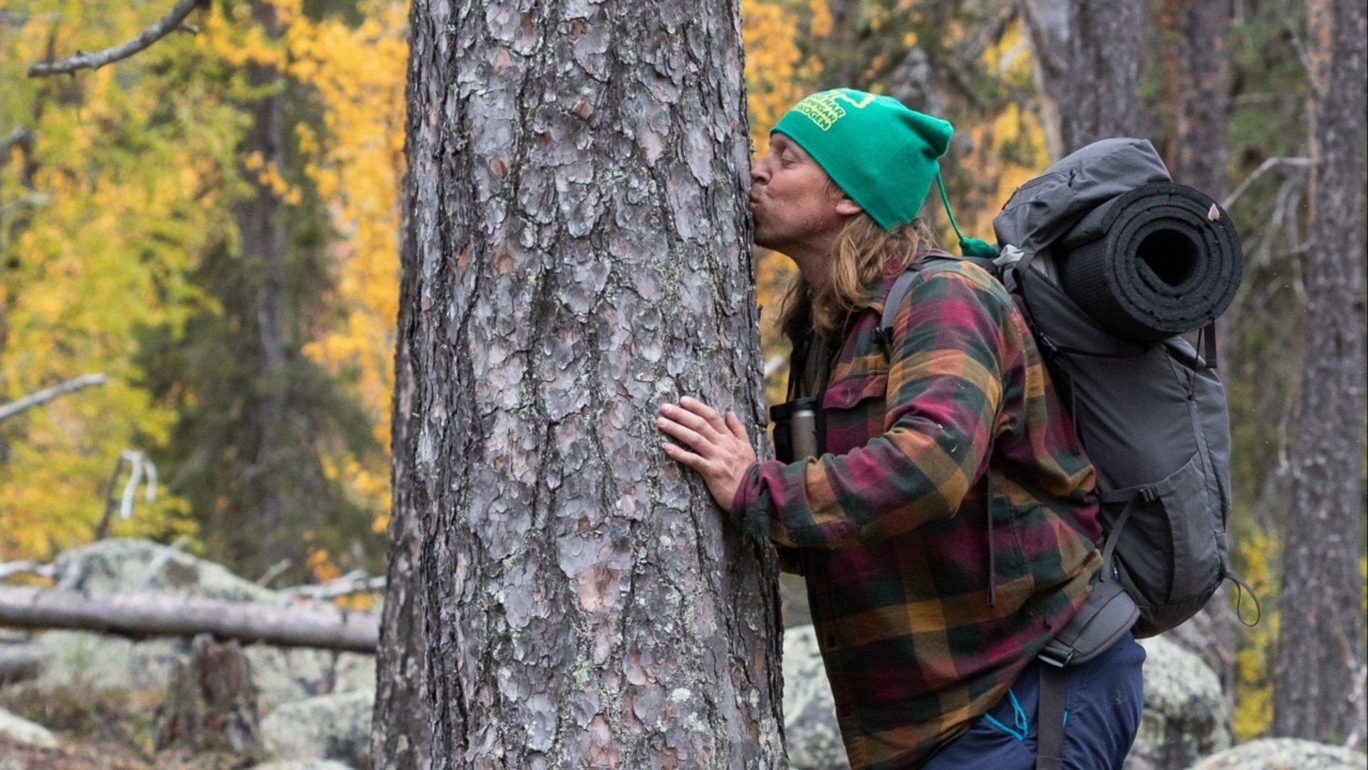 Föreläsaren Sebastian Kirppu står vid en tall som han kysser.