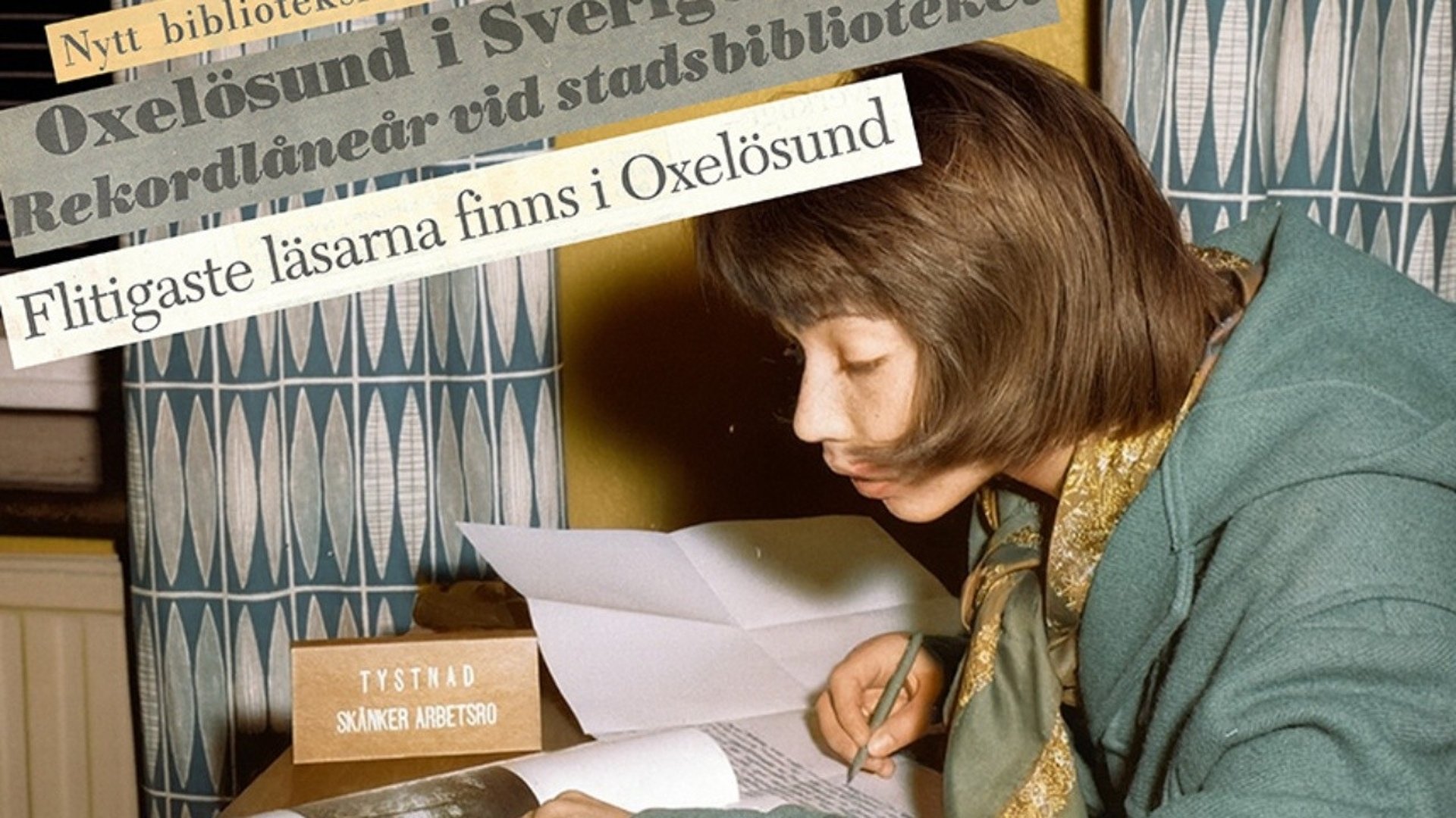 En flicka som sitter och läser en bok i biblioteket