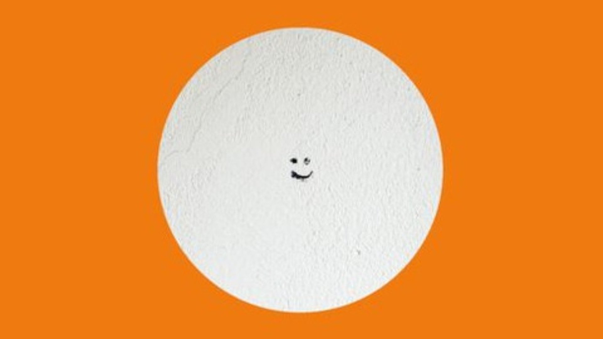 Vitt prick med ögon och mun på en orange bakgrund