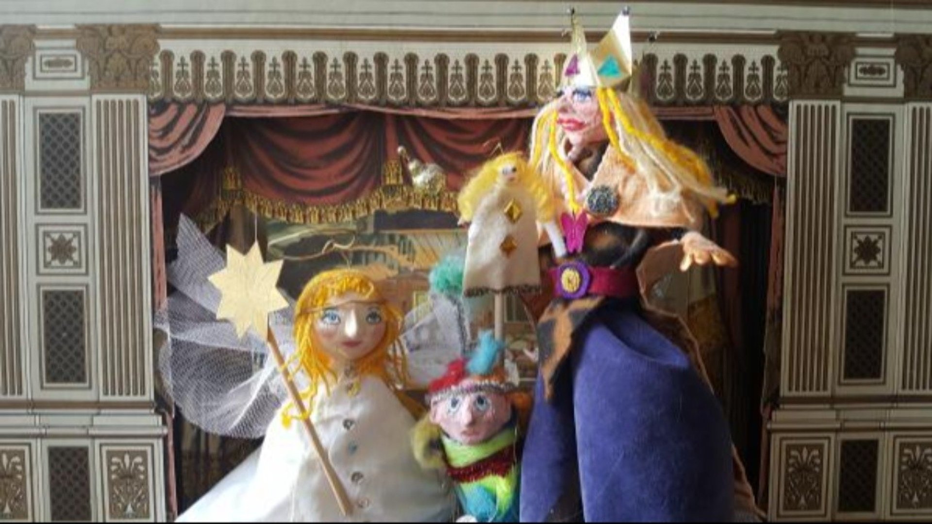 Tre handgjorda dockor framför en teaterscen i papper.