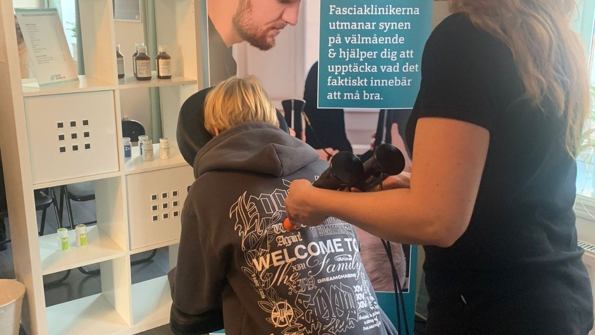 Terpeut som behandlar ryggen på en besökare med djupvågsmaskin