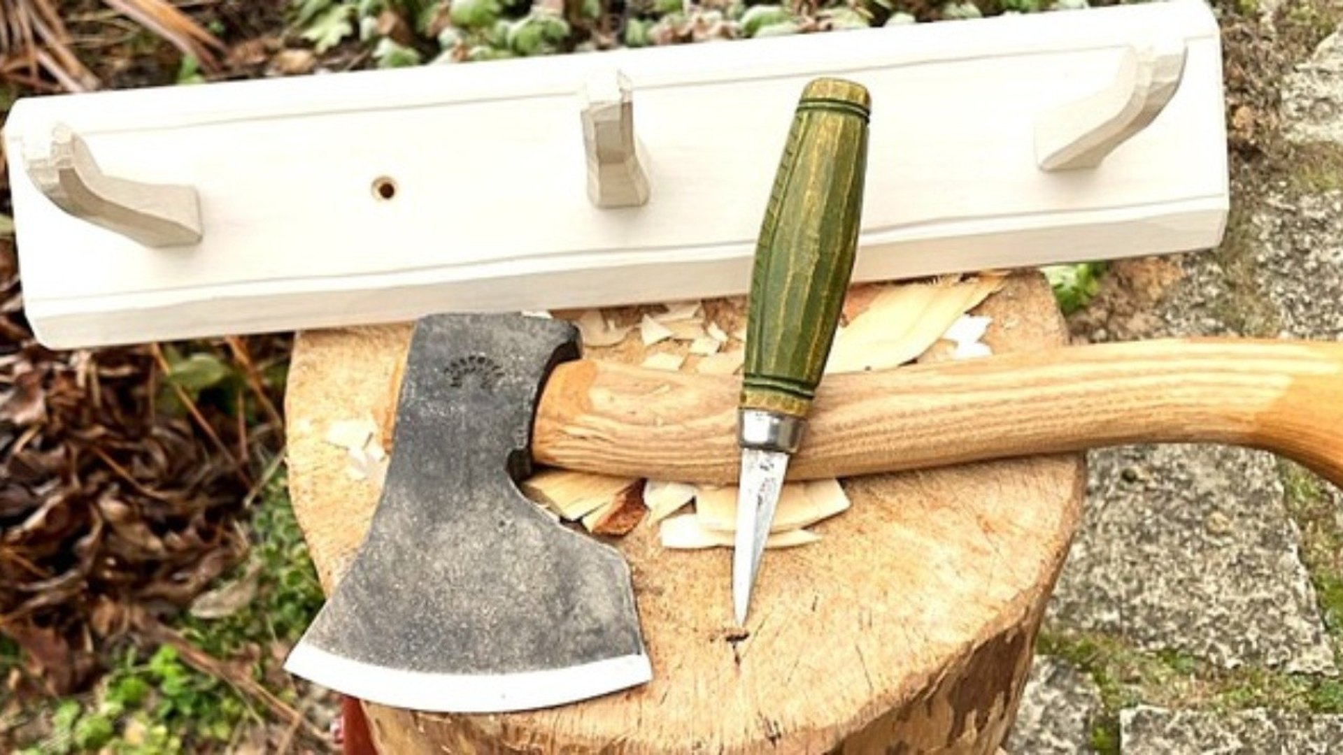 Yxa, kniv och knopplist på en huggkubbe