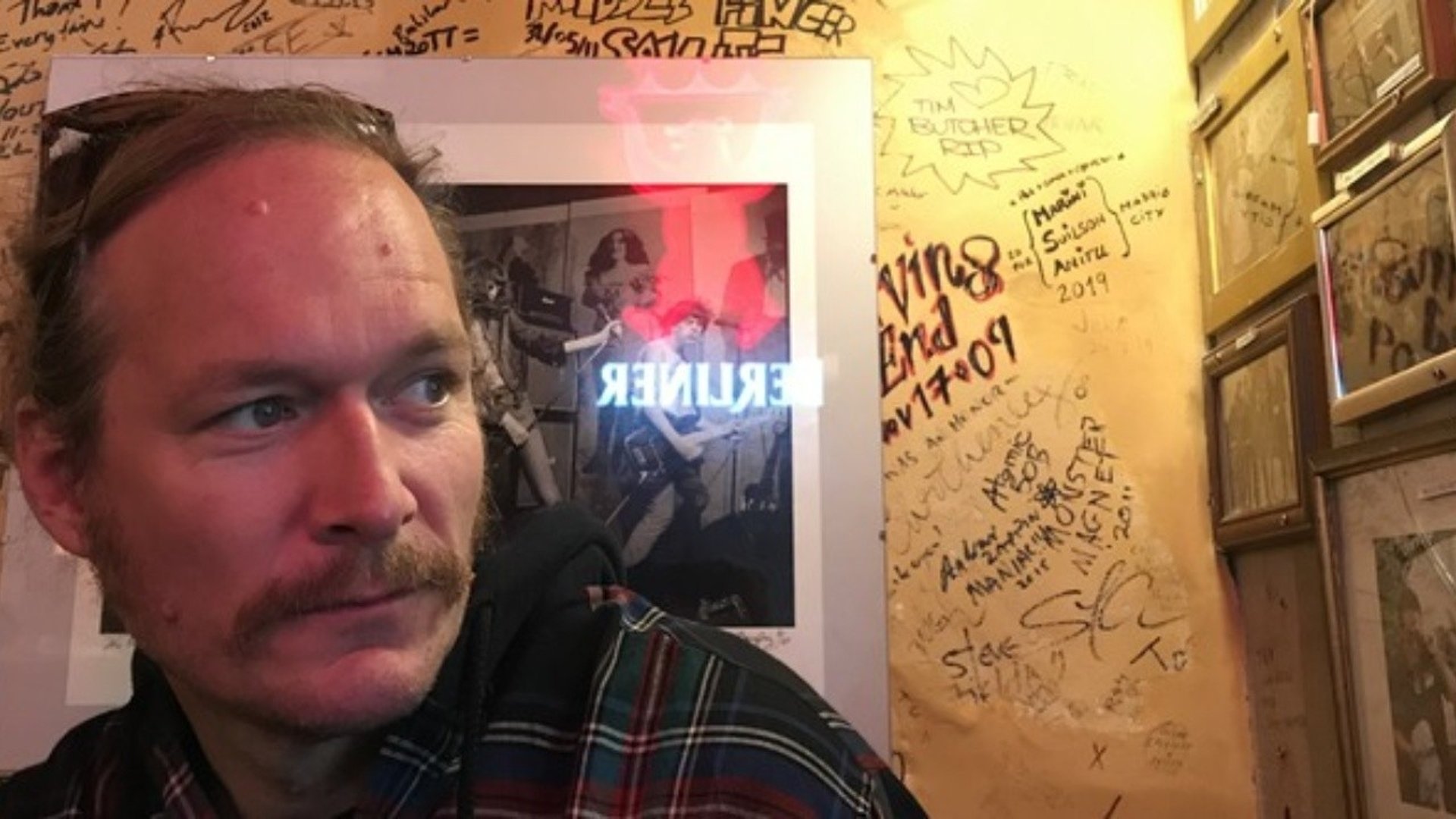 Man i mustasch och med solglasögonen uppe på huvudet tittar snett förbi kameran