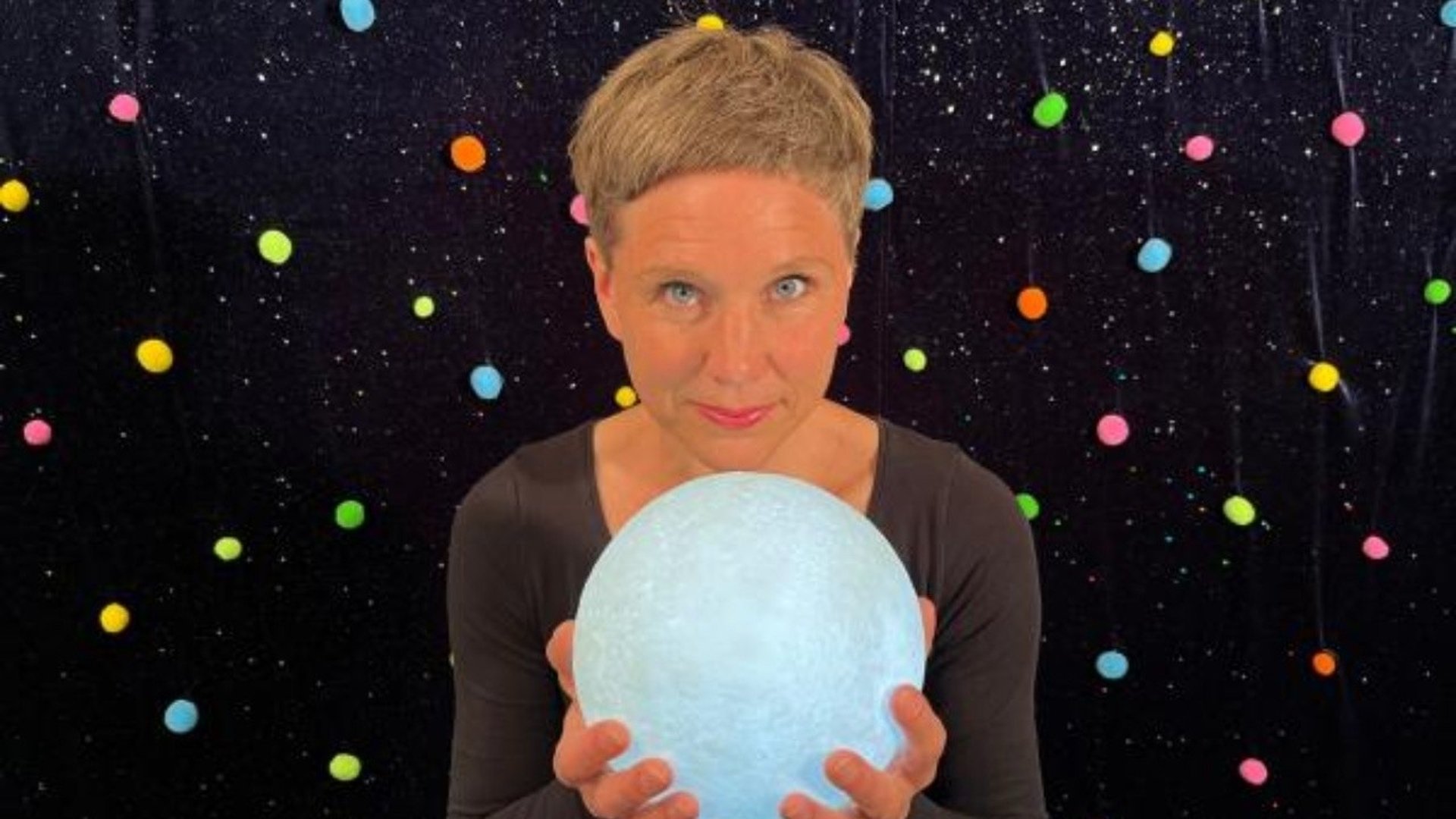 Bibliotekarien Elina står framför en stjärnhimmel med en lysande glob i händerna.