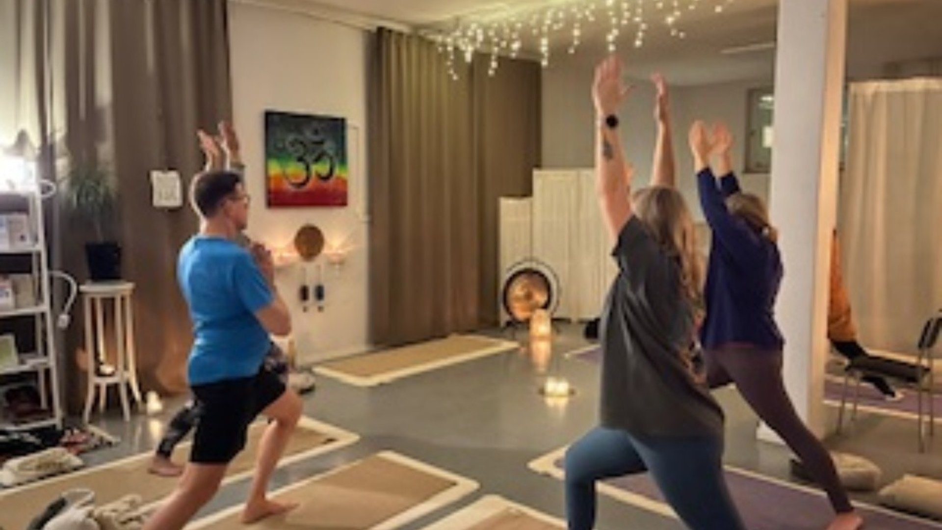 Bild på en yogalokal där man ser några personer som yogar.