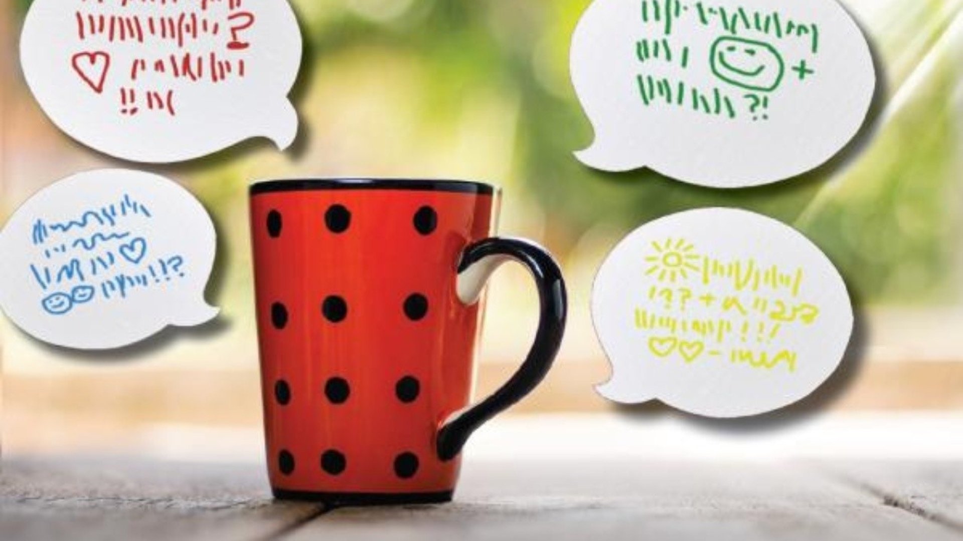 En röd kaffemugg med pratbubblor med olika språk.