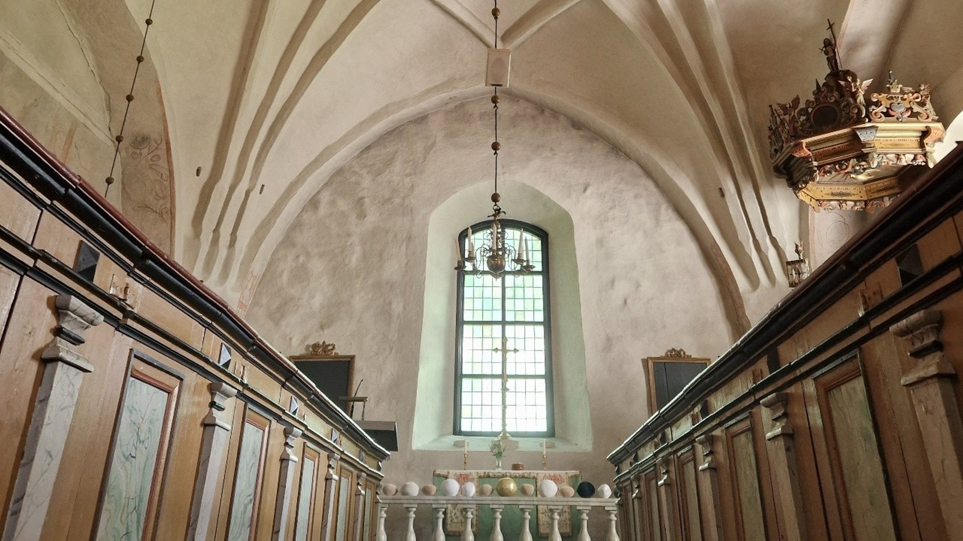 Interiör Bergshammars kyrka. Koret med frälsarkranspärlor på altarringen. Altare och korfönster.