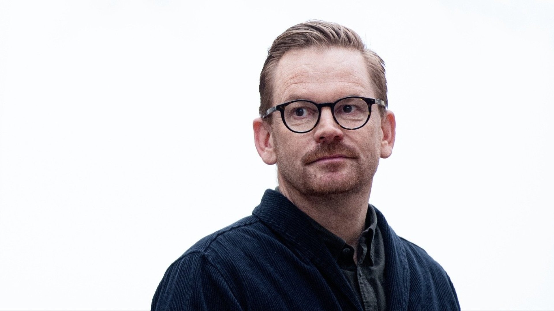 Professor Simon Sorgenfrei, rödlätt medelålders man i glasögon