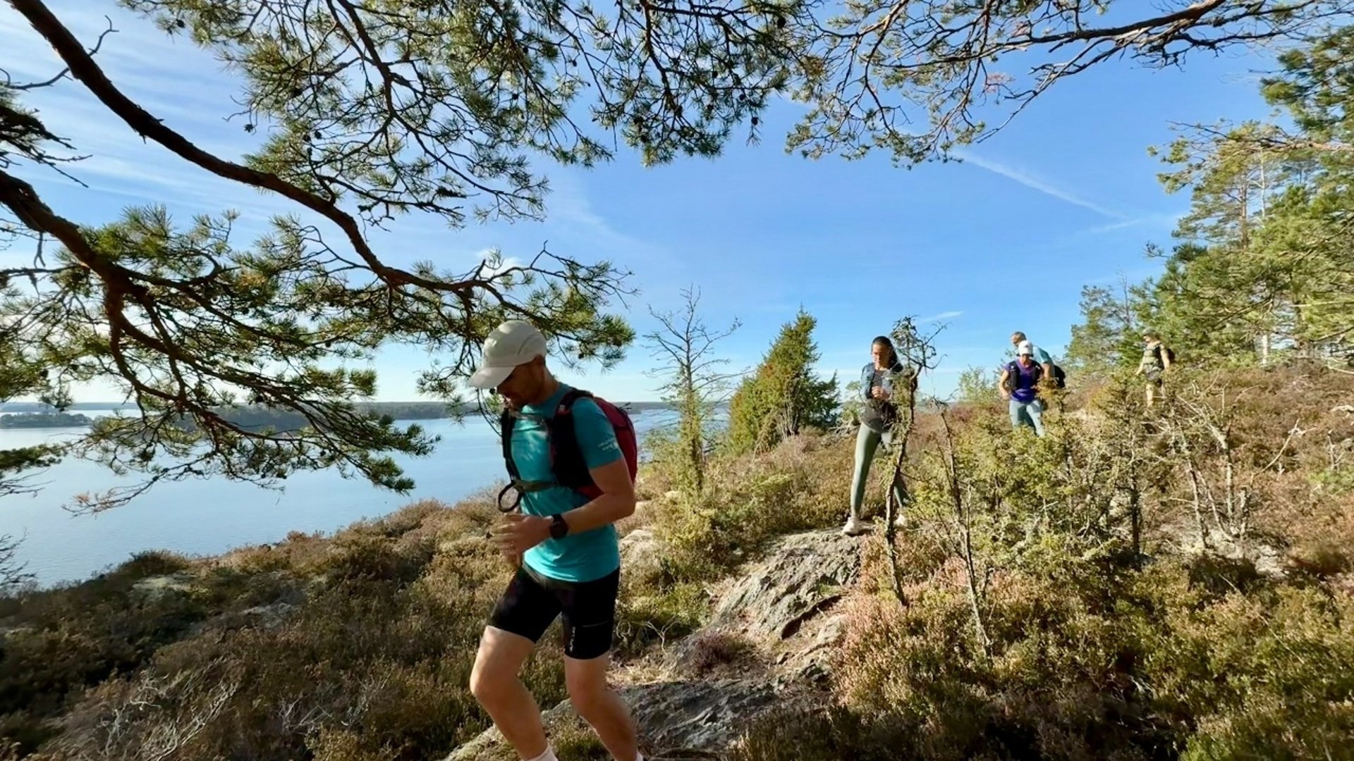 En grupp löpare som springer längs havet
