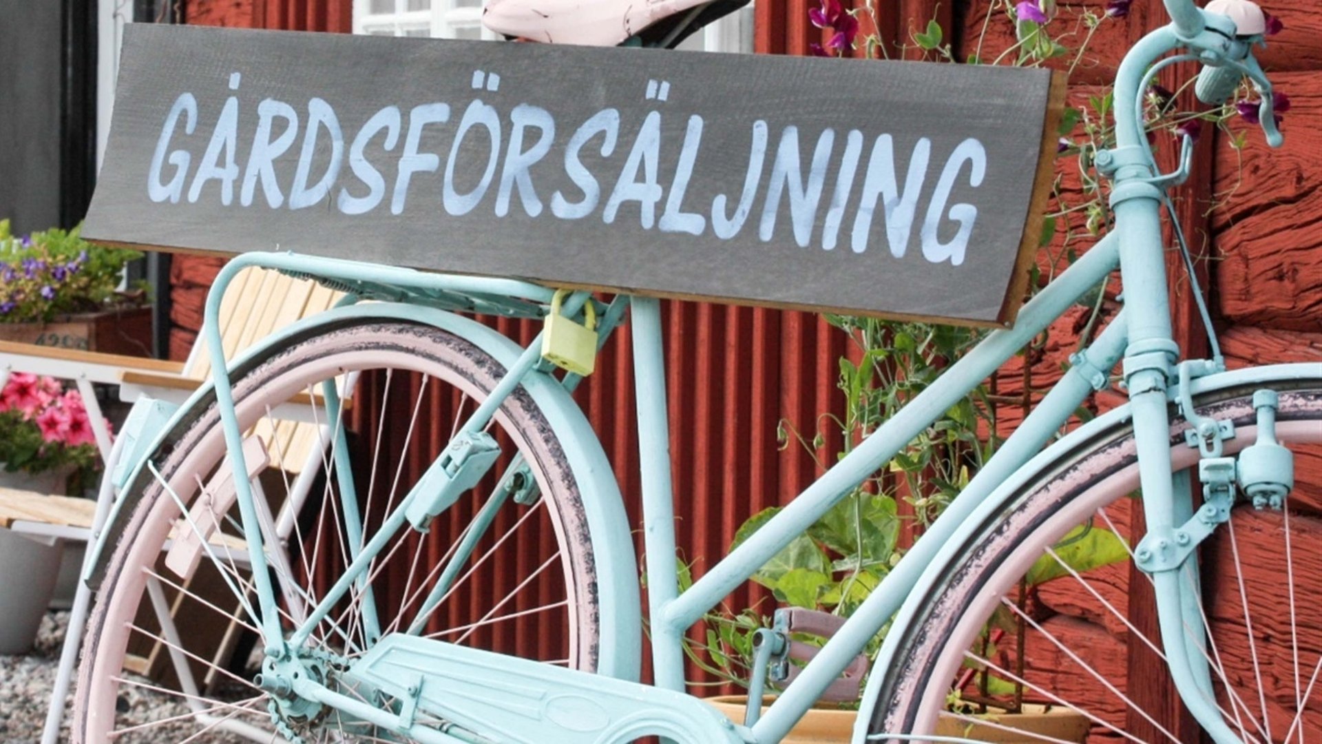 Blå cykel med en skylt, på skylten står det gårdsförsäljning. 