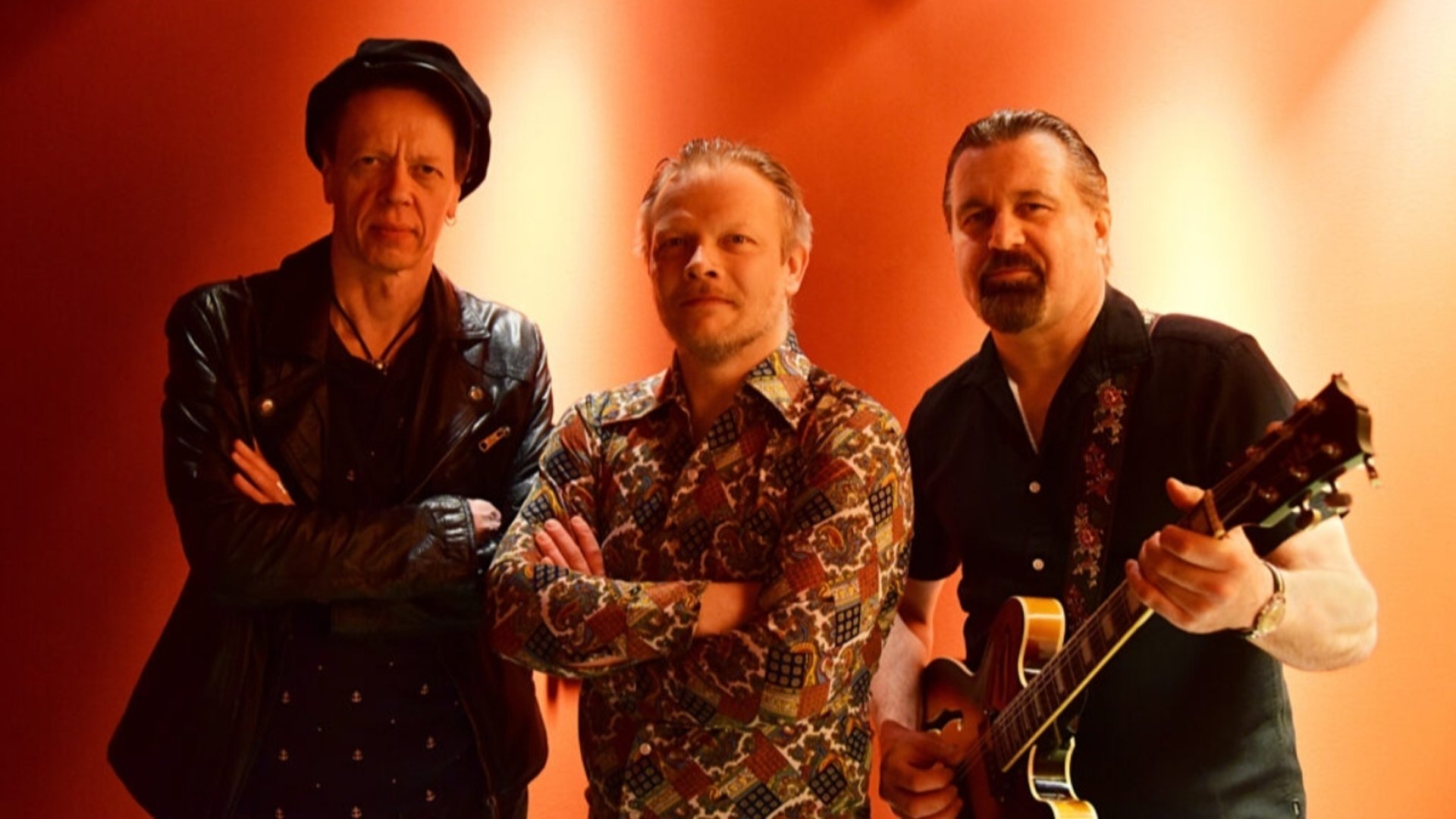 Tre musiker stående sida vid sida.