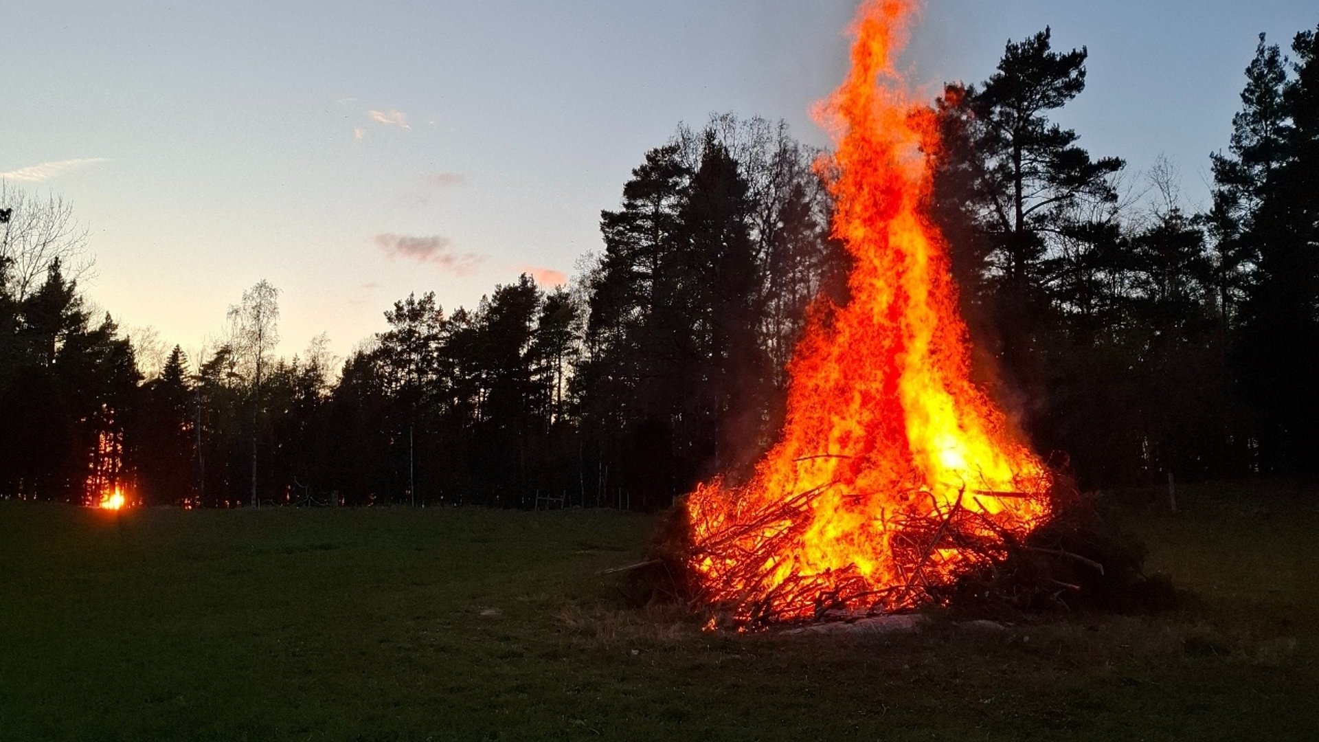 Valborgsmässoeld på Sävö med solen som går ner i bakgrunden.