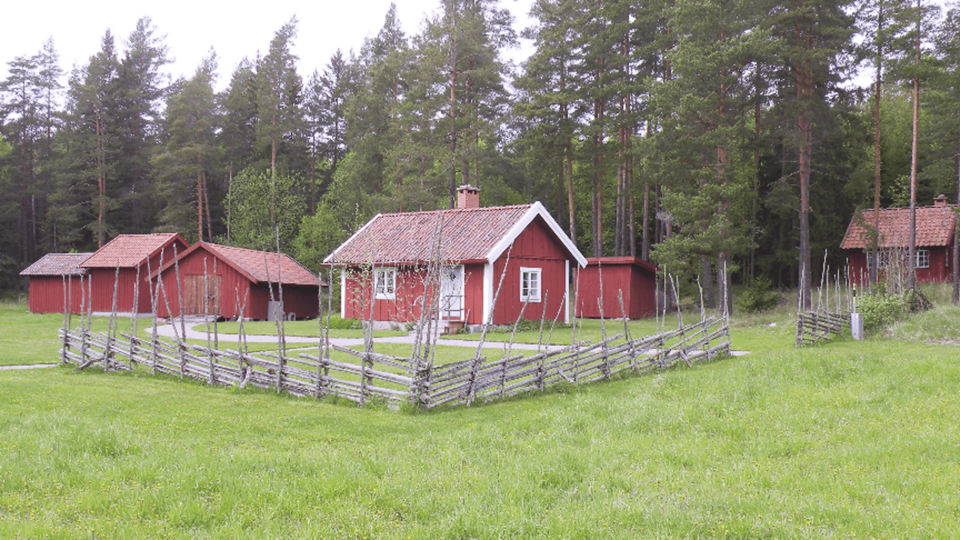Röda små hus och en gammalt trästaket.