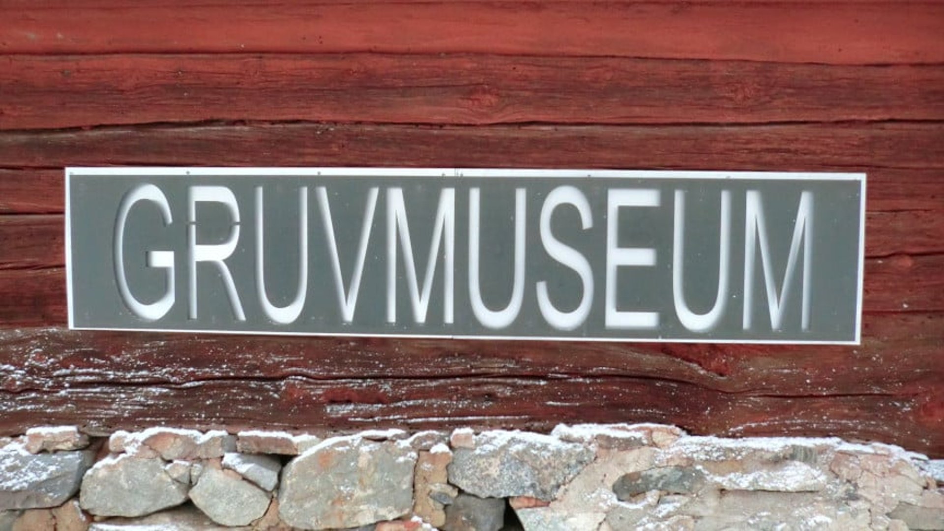 En rött hus med en skylt gruvmuseum