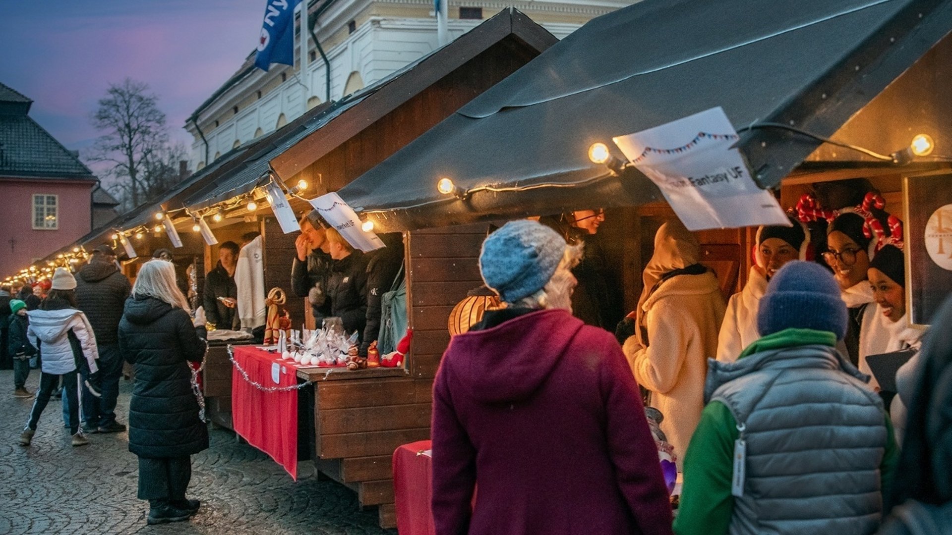 Människor som står och handlar på en julmarknad