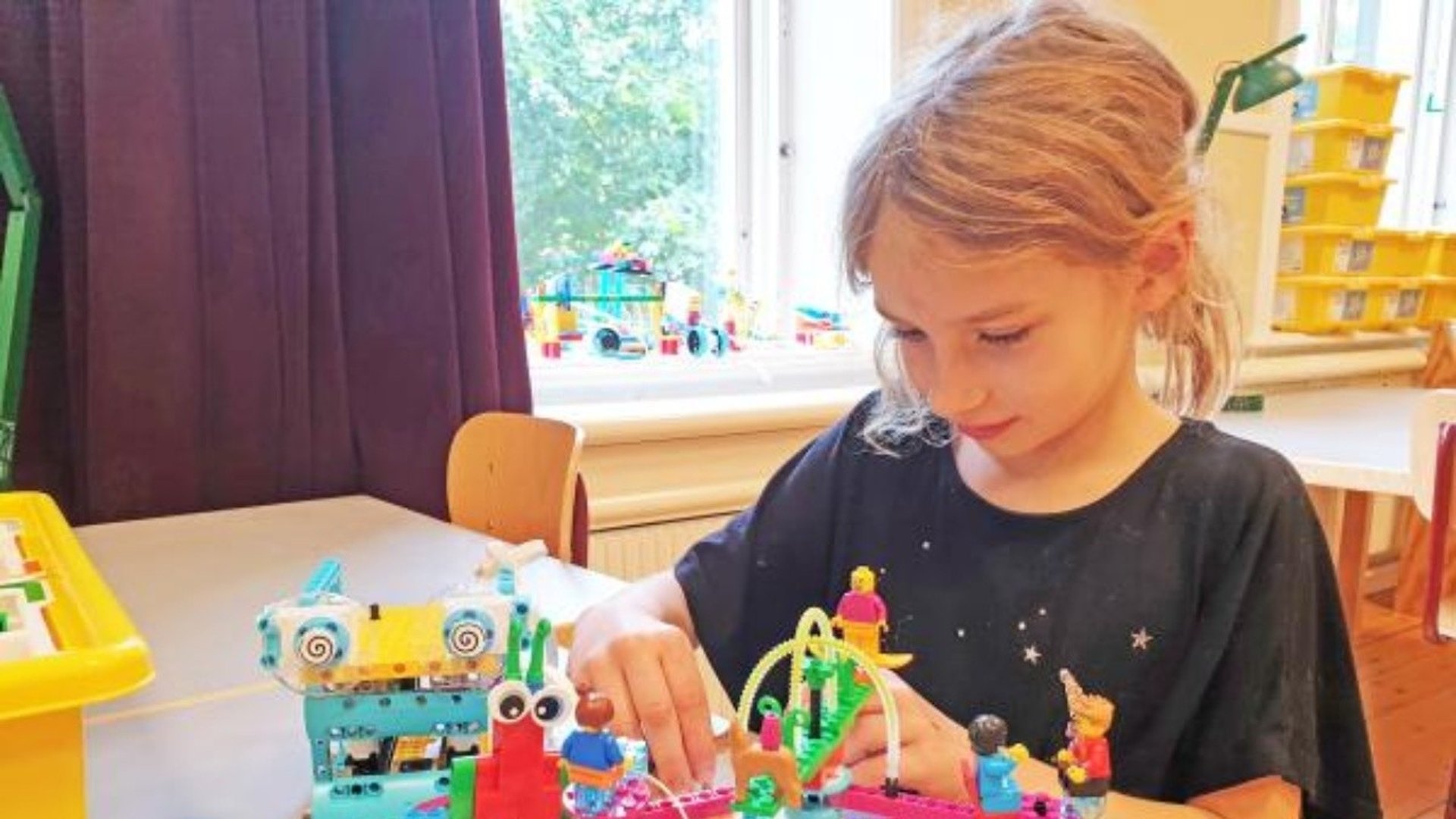 Ett barn sitter och bygger LEGO.