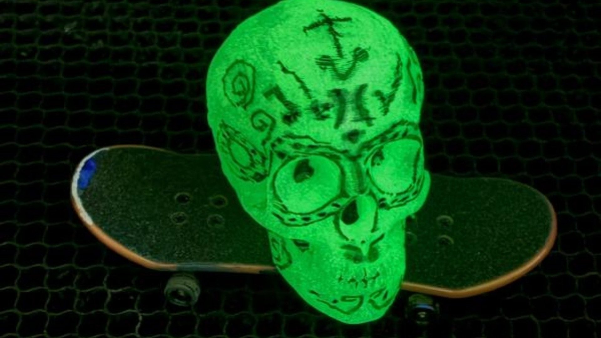 En självlysande grön dödskalle på en skateboard.
