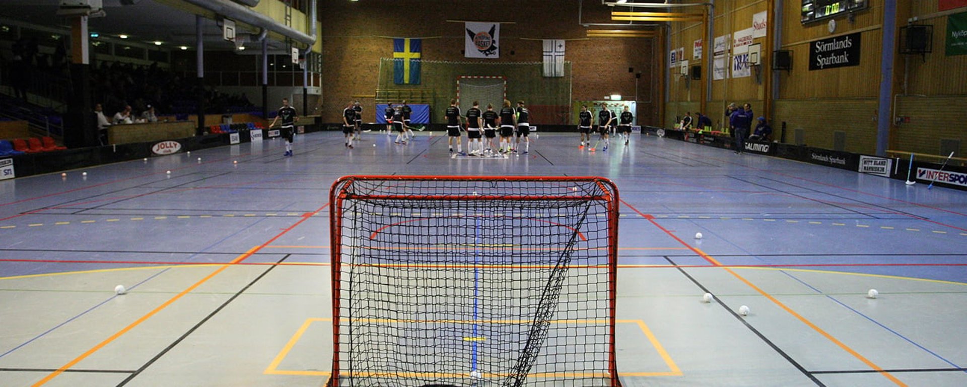 Ett innebandylag är samlat i en sporthall.