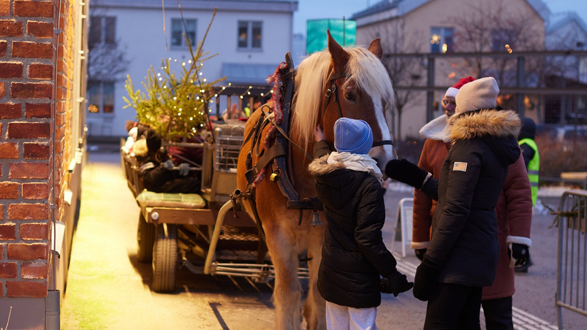 Människor som står vid en häst och vagn på en julmarknad