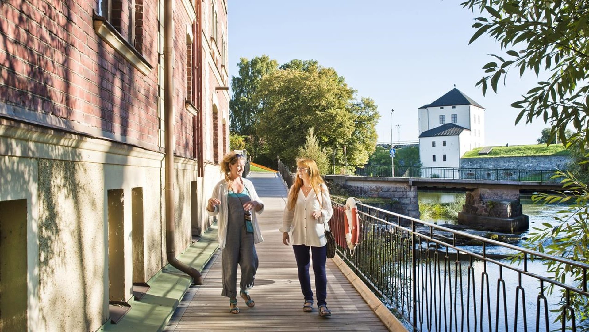 Två kvinnor som går längs med Nyköpingsån