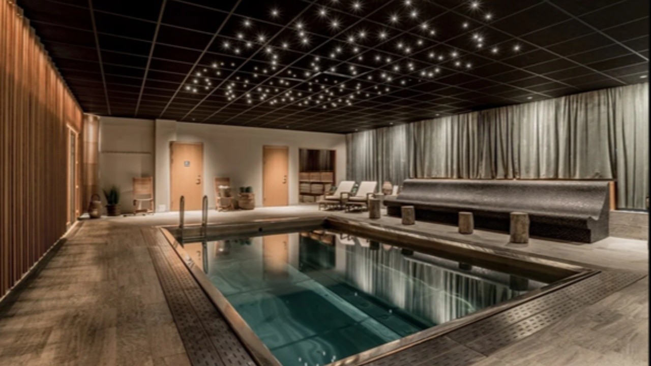 Inomhuspool på Blommenhof Hotell med lugn belysning och avkopplande spa‑miljö.
