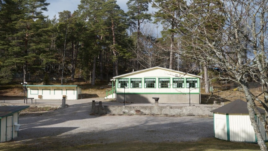 Nävekvarns Folkets park med sina gula hus med gröna detaljer: lotteribodar, kafé och två andra hus.