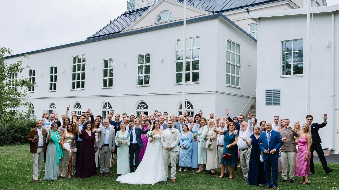 Bröllopssällskap framför hotellet. 