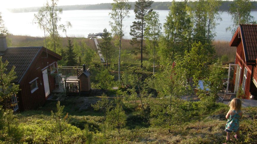 En röd stuga intill havet 