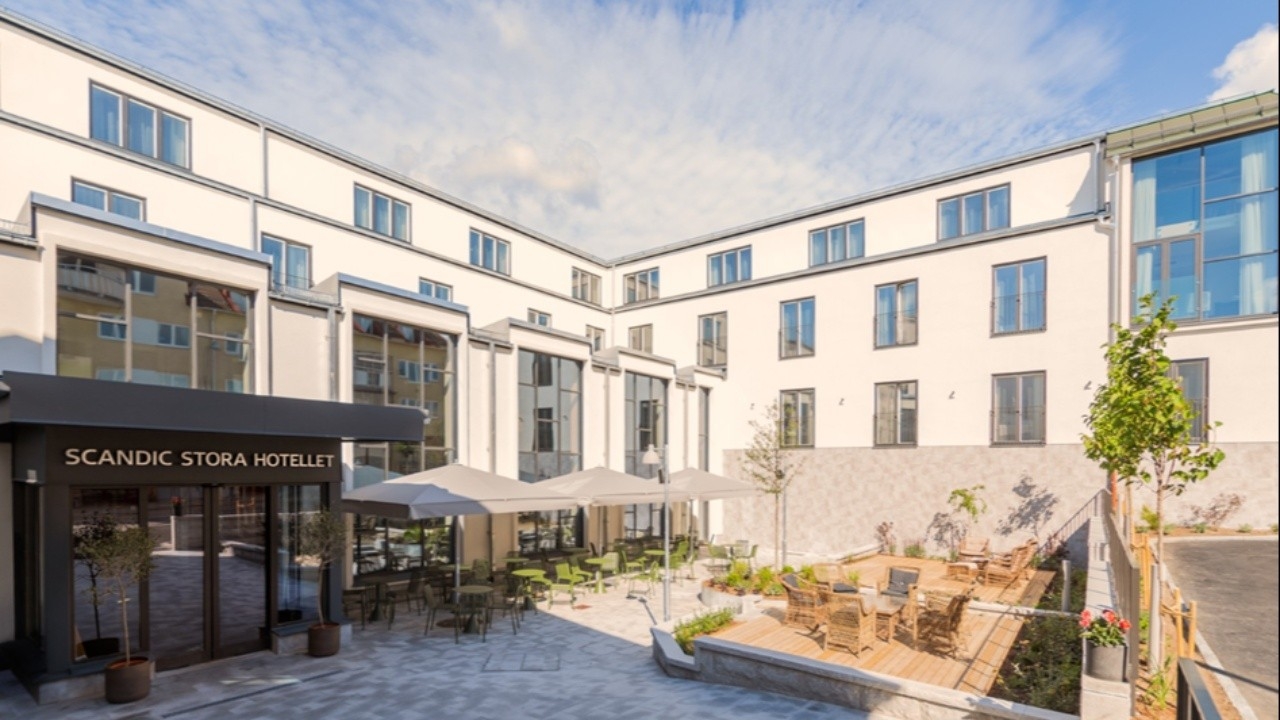 Entrén till Scandic Stora Hotellet i centrala Nyköping med uteservering i solen