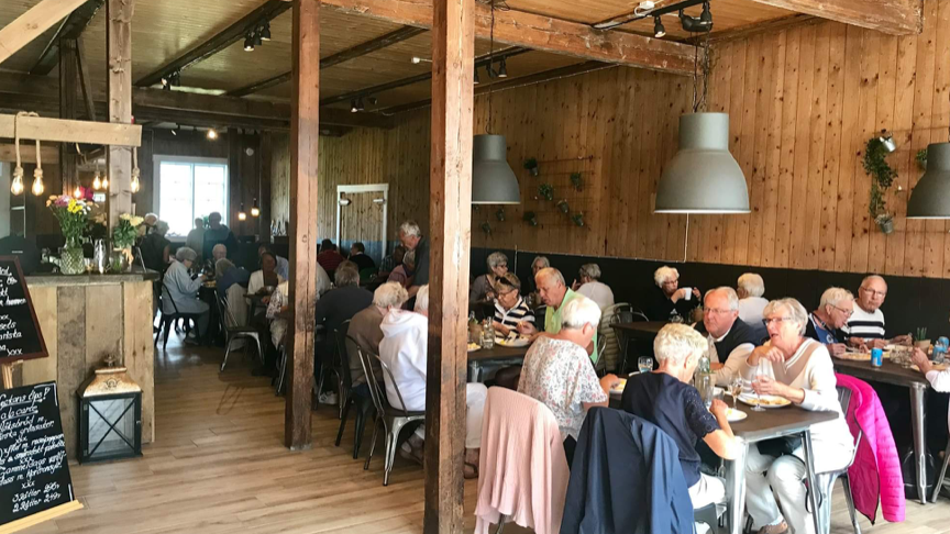 Flera människor som sitter och äter i en restaurang 
