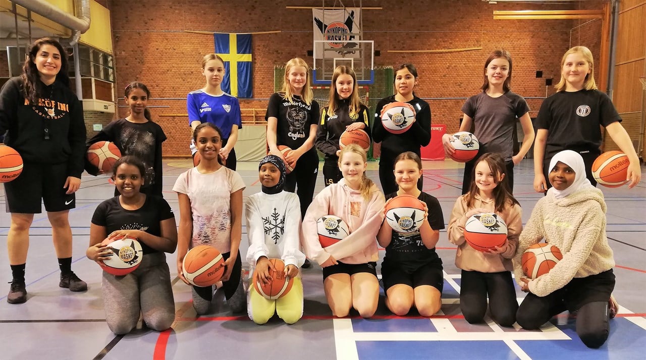 Barn som sitter och står med en basketboll i händerna