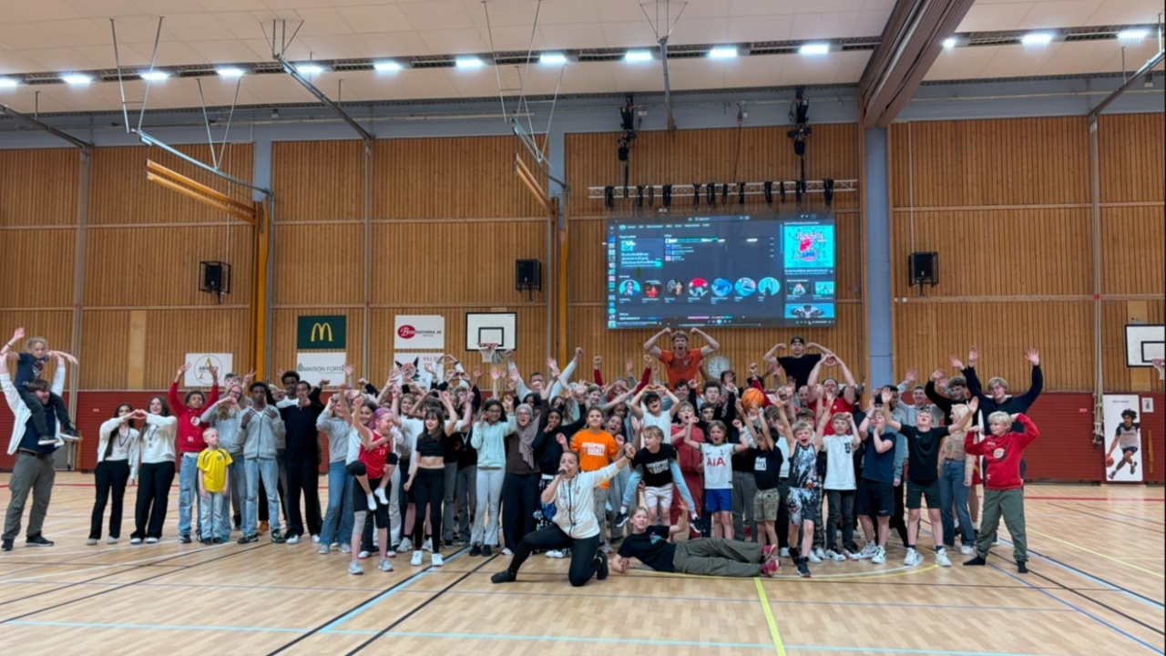 Flera barn i Sporthallen som spelar basket.