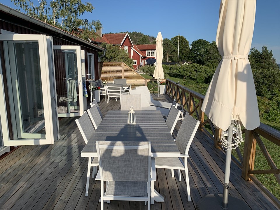 Terrass med utemöbler och röda hus i bakgrunden