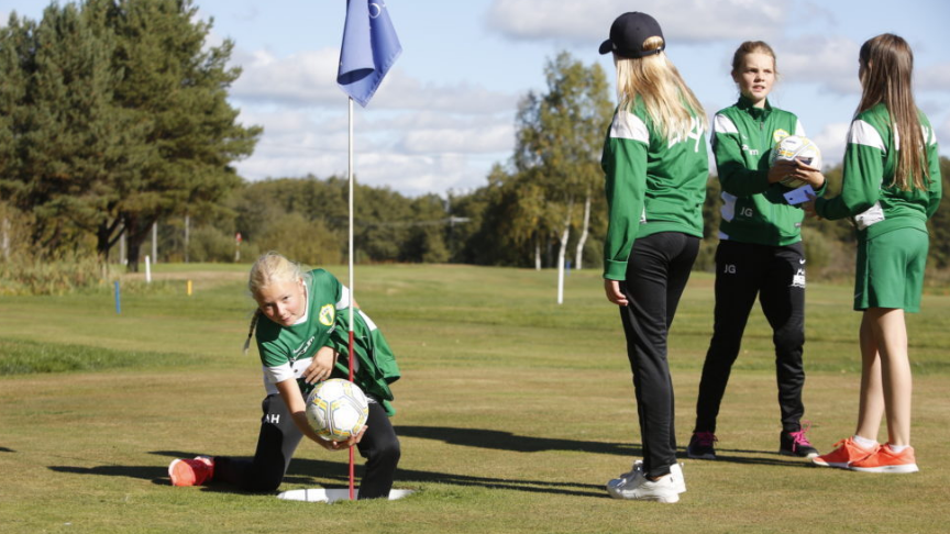 Tjejer som spelar fotbollsgolf
